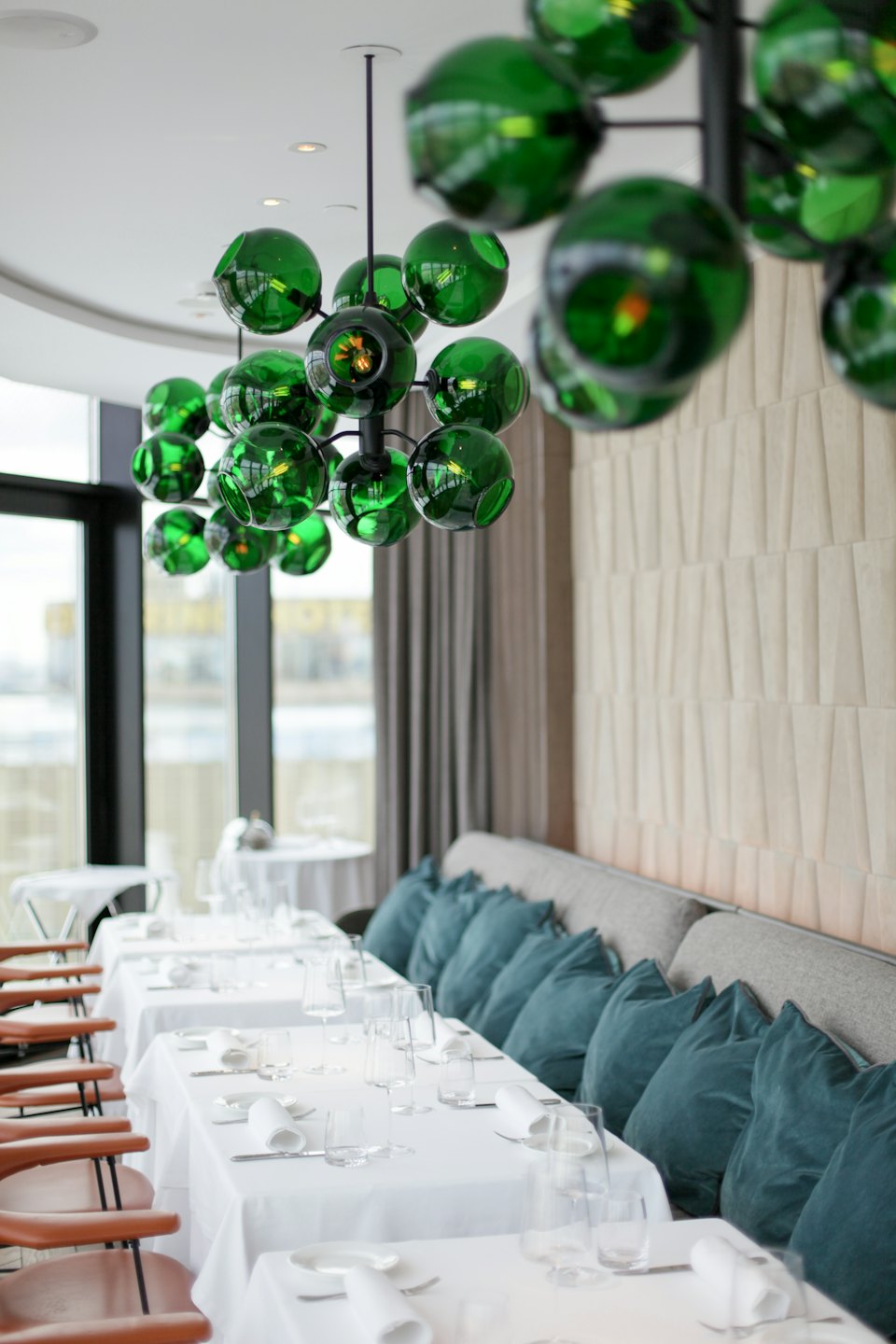 Comedor de restaurante moderno con candelabro de cristal verde.