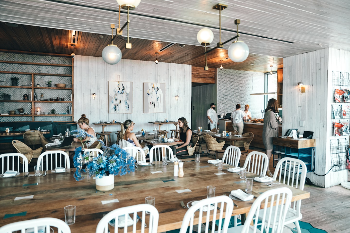 Clientes y personal en un concurrido y moderno comedor de restaurante.